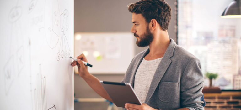 Man calculating financial ratios on whiteboard