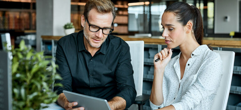 people looking at tablet discussing a small business budget