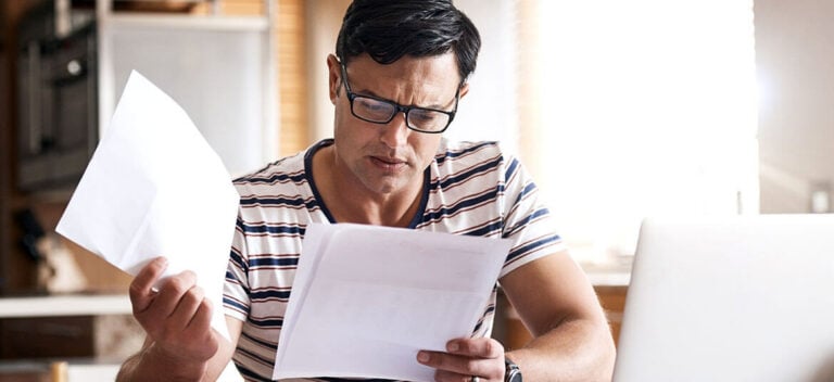 Picture of man examining papers with current liabilities