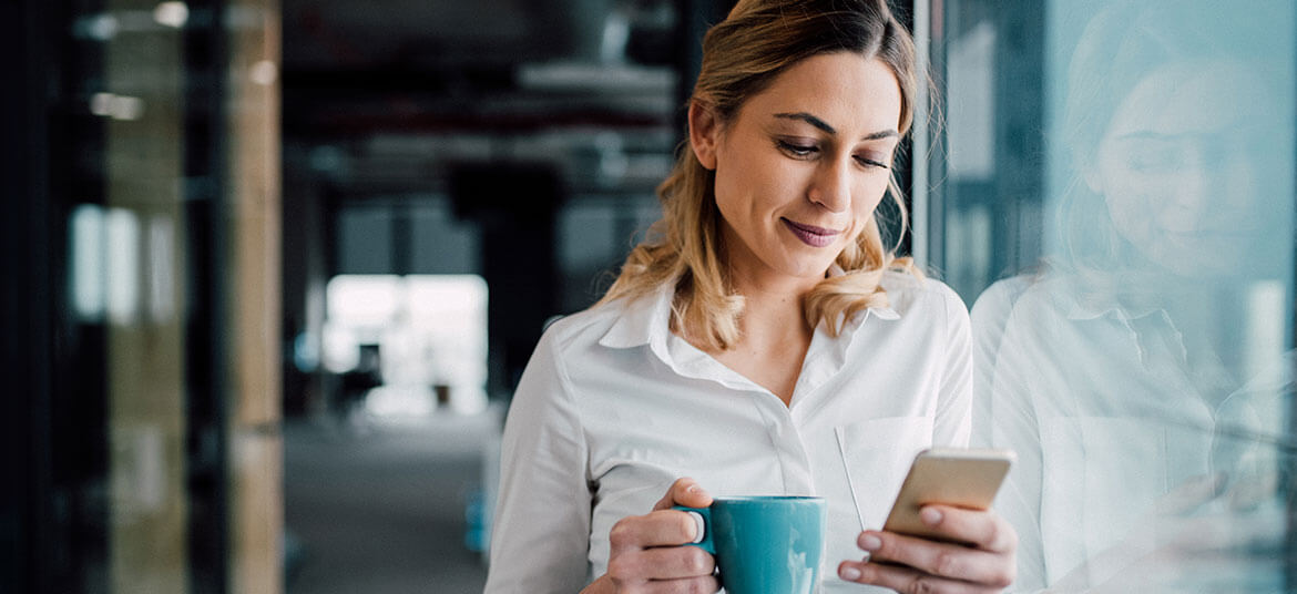 Woman looking at a mobile phone thinking about e-invoicing